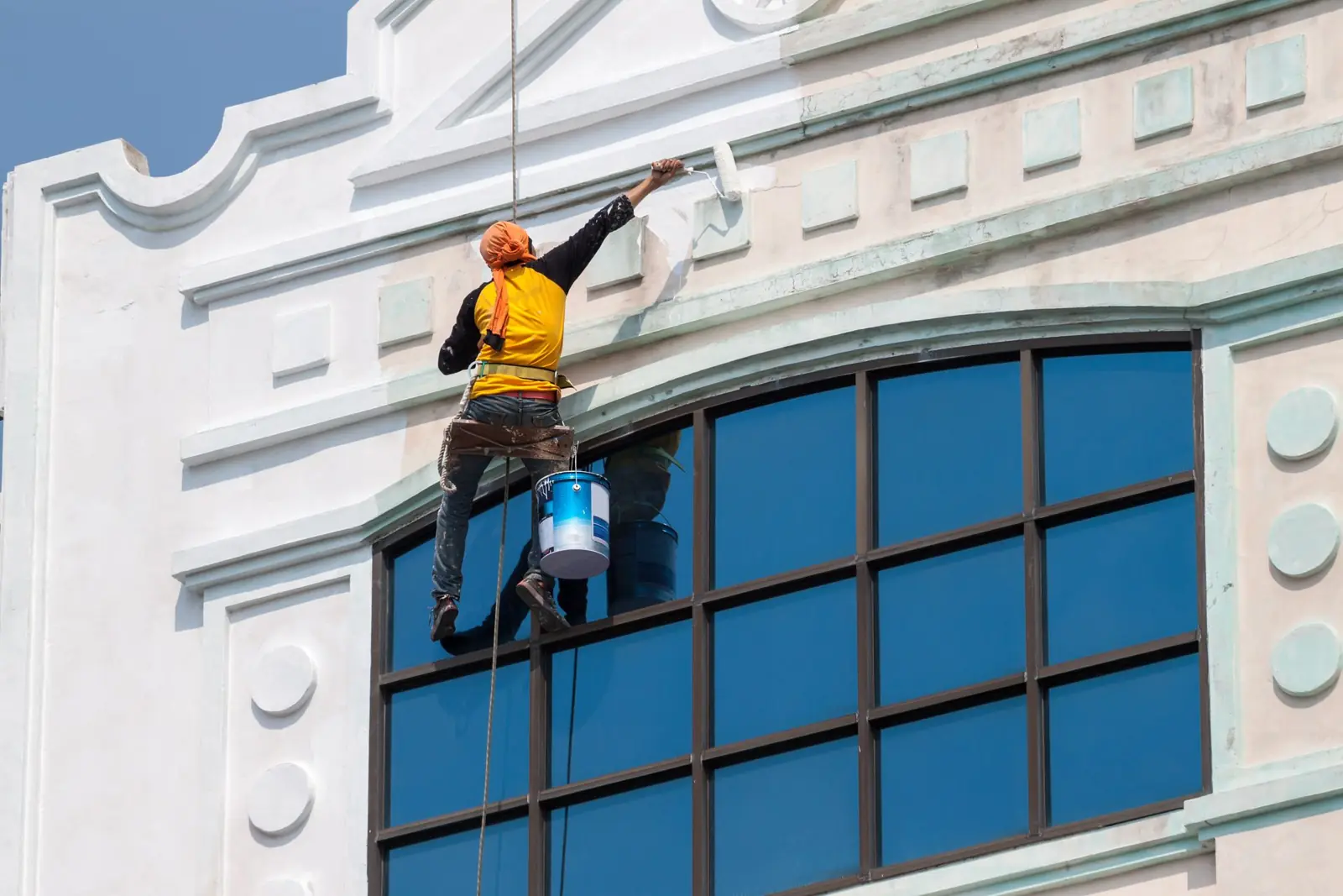 Painter working on a commercial building facade