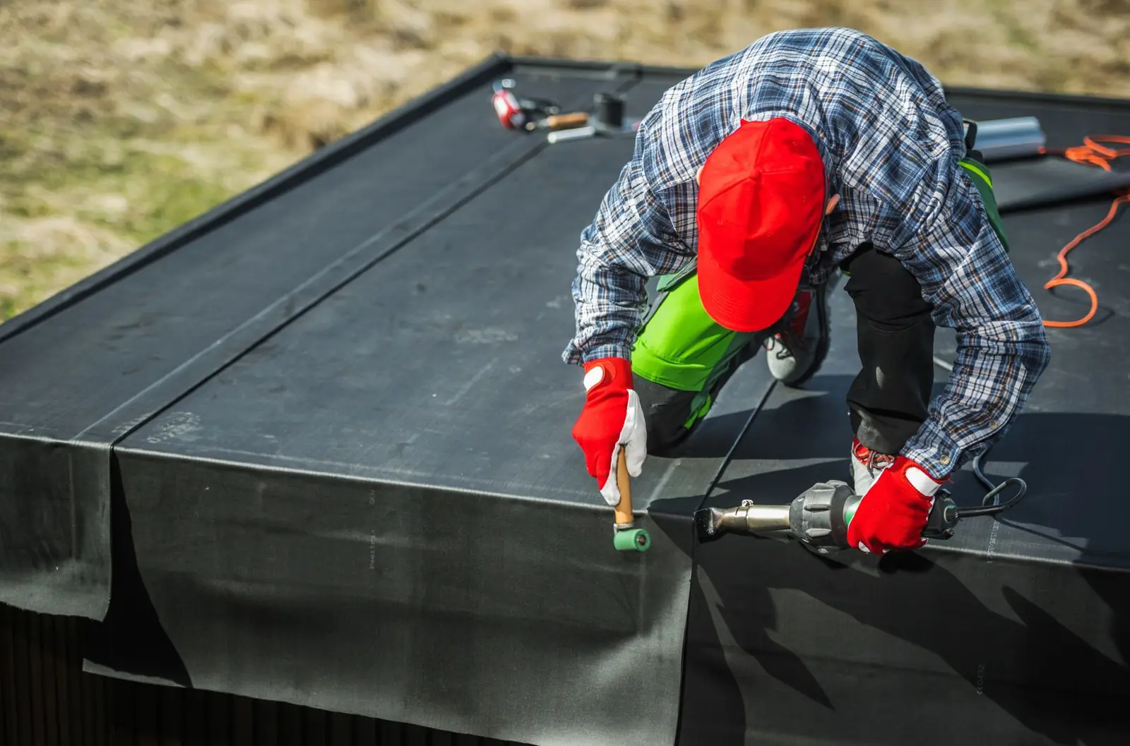 Roofer sealing a flat roof membrane