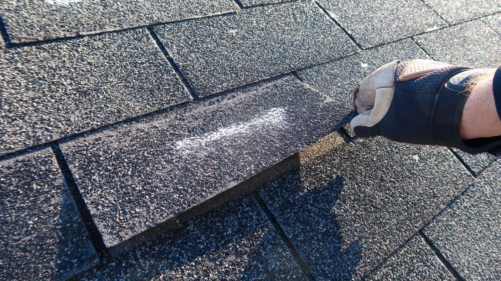 Roofer applying sealant to a flat roof seam