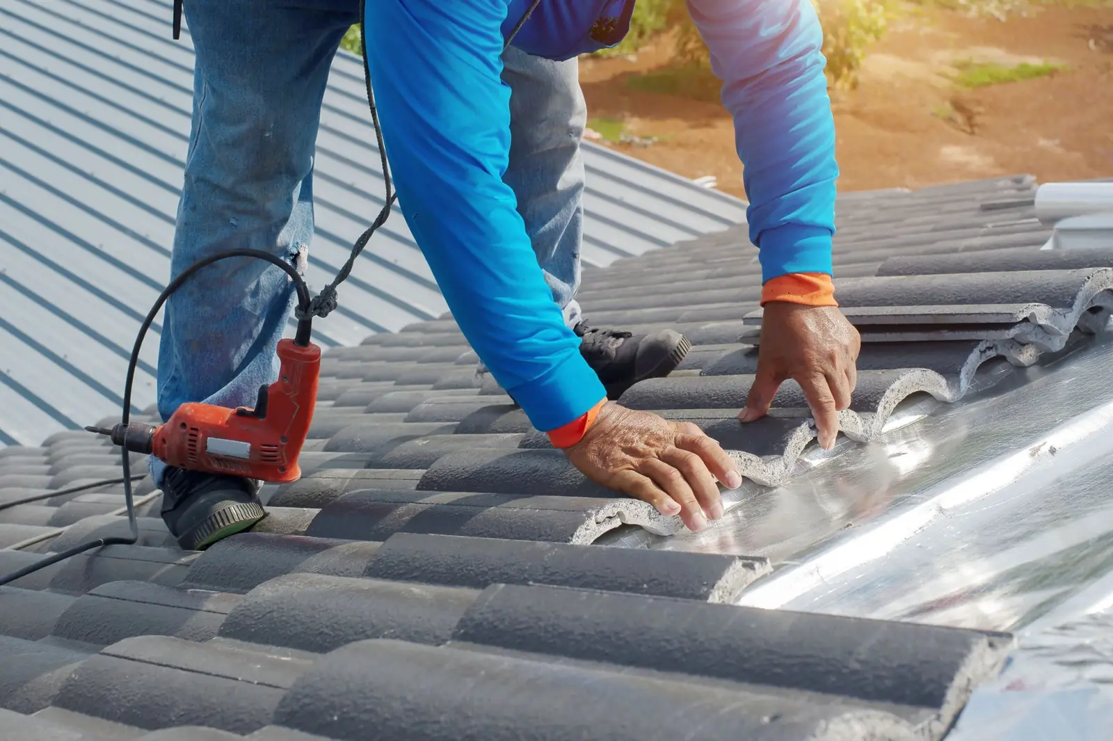 Roofers repairing a concrete tile roof